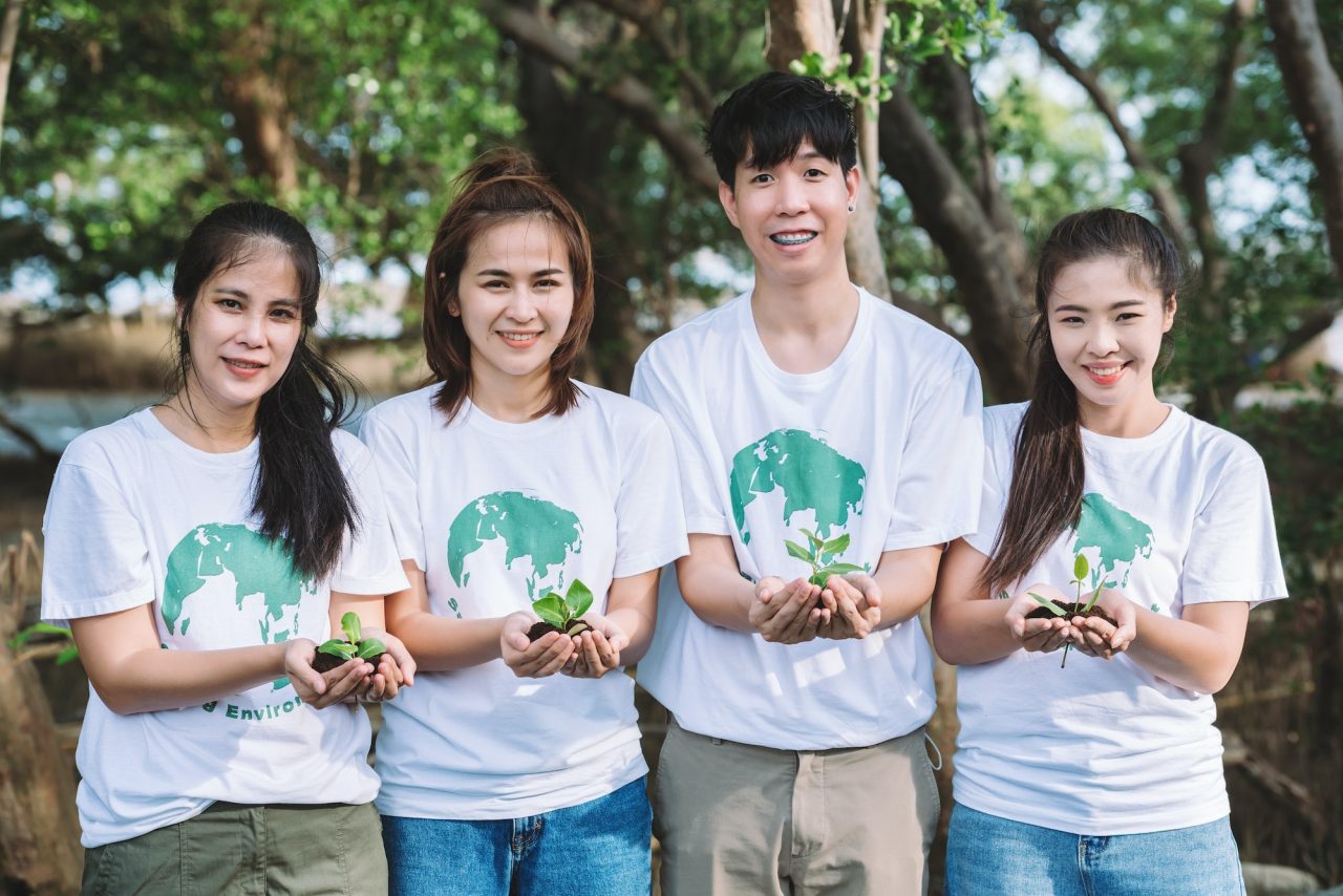 volunteer-people-teamwork-holding-small-plants-seedling-for-growing-in-forest.jpg